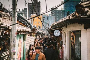 A group of people walking down a crowded Seoul street